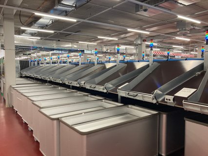 Spring-loaded base trolley at the parcel sorter chute for E-Commerce Fullfillment